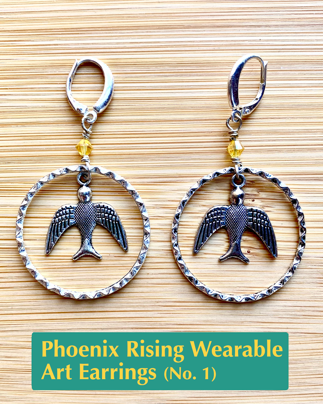 Handmade, wearable art lever back earrings with yellow crystal accents, a silver bird charm dangle, inside of textured hoops