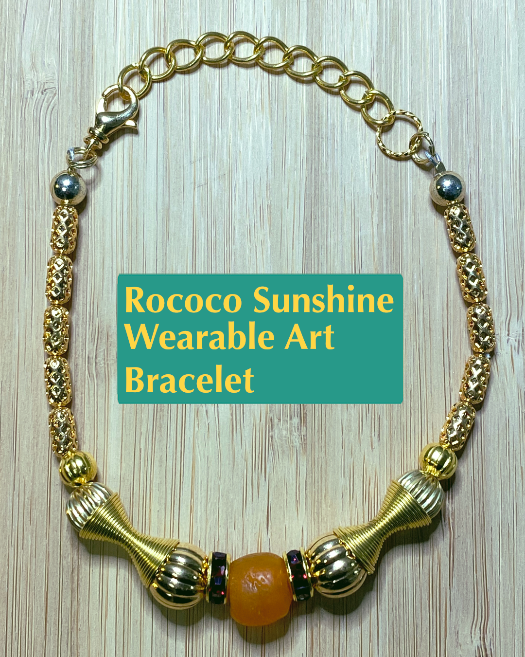 Handmade wearable art gold colored bracelet with gold, orange, and red focal beads