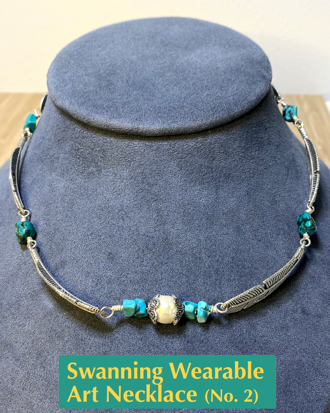 Handmade, wearable art necklace made from silver feather charms with turquoise colored chip beads and a faux black pearl